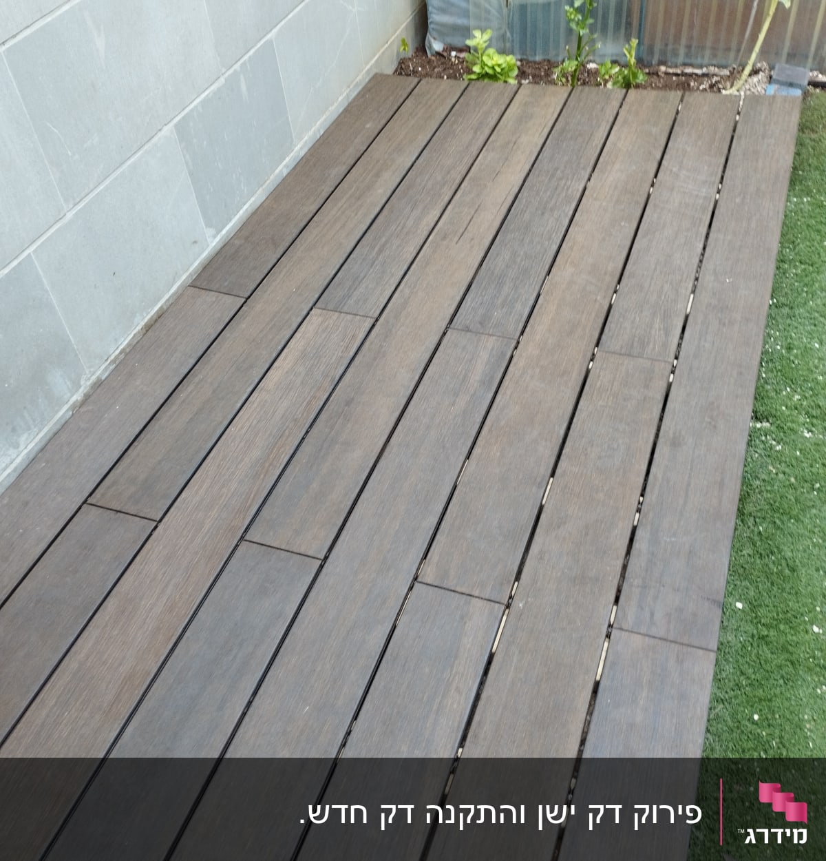 רצפת עץ חומה ליד קיר אבן וצמחים קטנים